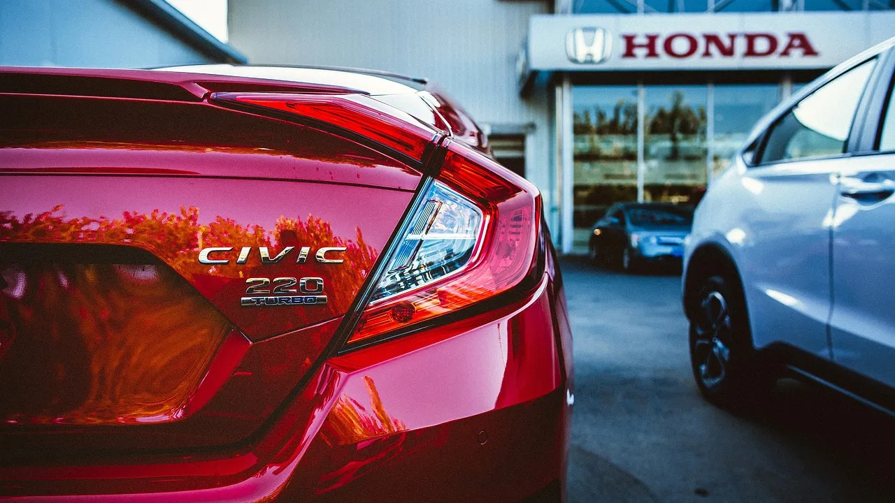 Logo Honda em fachada de concessionária com modelos híbridos em destaque