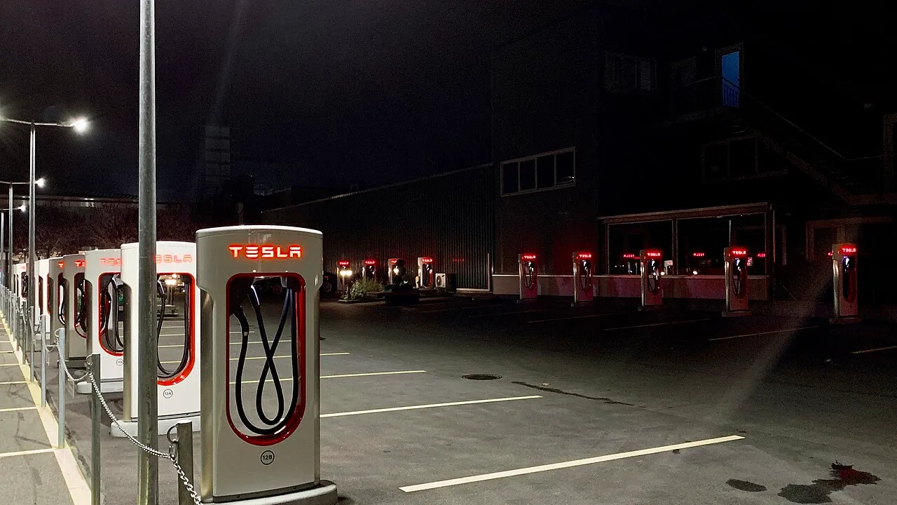 Estação Supercharger Tesla com fila de veículos elétricos em horário de pico